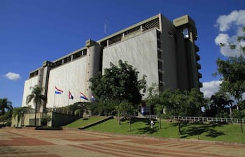 Edificio del BCP en un día soleado, rodeado de césped y árboles, sin personas visibles.
