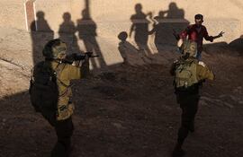 Soldados israelíes apuntan con sus armas a un palestino durante una operación en la localidad de Baita, en Cisjordania, el pasado 21 de agosto.