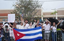 Miembros de la comunidad cubanoamericana se congregan a un lado de la carretera al paso de la caravana presidencial de Donald Trump el 15 de marzo de 2026 en West Palm Beach, Florida.