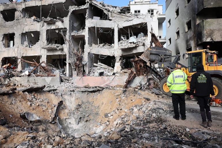 Personal de los servicios de emergencia inspecciona los daños en el lugar del impacto de un misil iraní en Tel Aviv, Israel, el 1 de marzo de 2026.