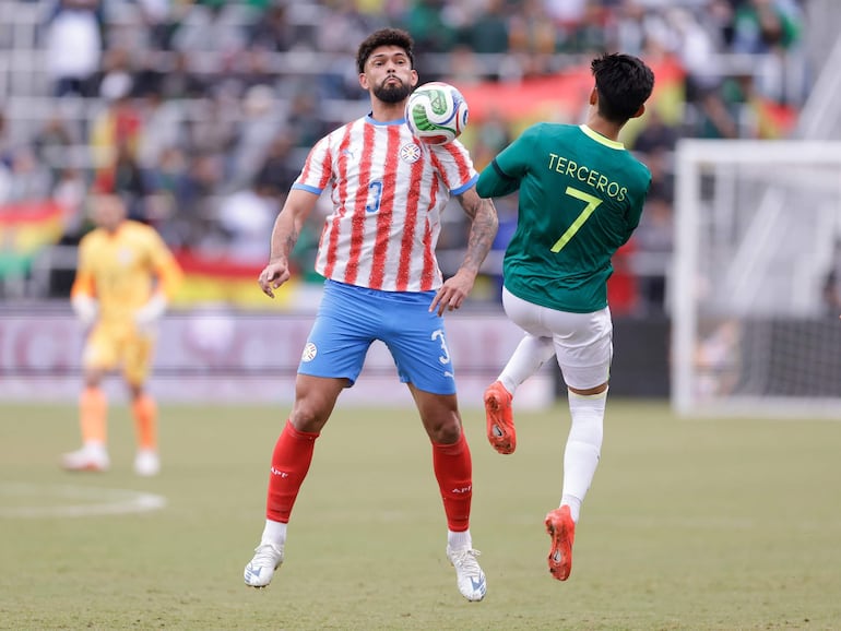 Omar Alderete (i), jugador de la selección de Paraguay, disputa el balón en un partido amistoso frente a Bolivia por la Fecha FIFA de setiembre-octubre en el estadio Audi Field, en Washington D.C., Estados Unidos.