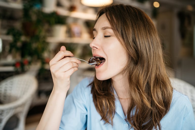 Persona feliz comiendo postre.