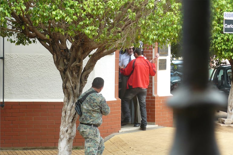 Uno de los asaltantes (campera roja) reingresa al Banco de la Nación Argentina de Concepción, con uno de los rehenes, al quedar rodeados por la Policía, el 3 de octubre de 2013.