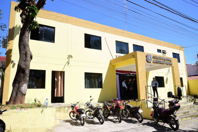 Edificio amarillo de la Policía Nacional con varias motocicletas estacionadas, en un día soleado y rodeado de vegetación.