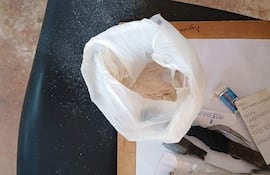 Superficie con bolsa plástica marrón y objetos, sin presencia de personas ni textos claros.