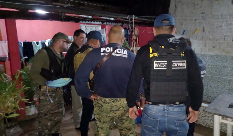Policías de Investigaciones y Antinarcóticos en la casa allanada en Capitán Bado.