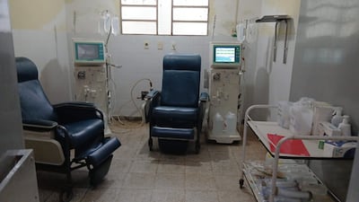 Sillones de hemodiálisis en un hospital, con máquinas y suministros médicos visibles en un ambiente desgastado.