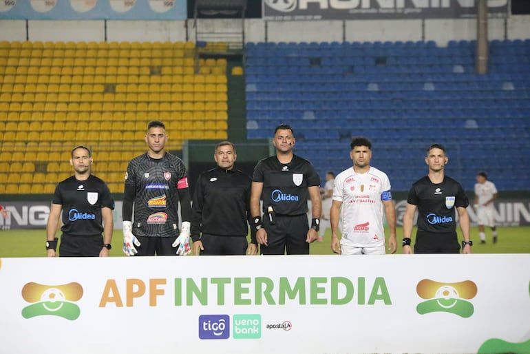 La terna arbitral posa con los capitanes de ambos equipos en la previa del partido.
