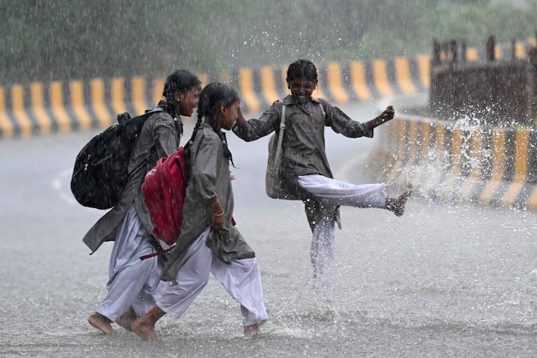 Niñas juegan en la lluvia en Nueva Delhi.