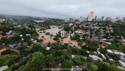 Vista aérea de Ciudad del Este con casas rodeadas de agua marrón y vegetación en medio de inundaciones.