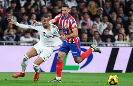 Los franceses Kylian Mbappé, jugador del Real Madrid, y Clement Lenglet, futbolista de Atlético Madrid, disputan el balón en un partido en el Santiago Bernabéu, en Madrid, España.