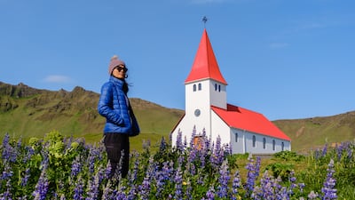 Una viajera cerca de la iglesia de Vik en Islandia.