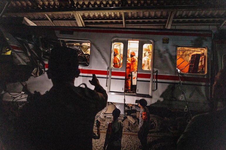 Rescatistas buscan a sobrevivientes del accidente ferroviario ocurrido en Indonesia, anoche. 