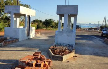 Estas son las casillas construidas con recursos privados en la futura vía de acceso al puente internacional. Al fondo se ve la majestuosa pasarela, acogotada por la invasión de “paseros” de ambas orillas.