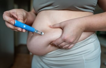 Mujer se inyecta medicamento para bajar de peso.