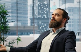 Hombre practica la técnica de atención plena en su oficina.