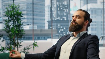 Hombre practica la técnica de atención plena en su oficina.