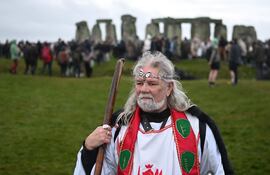 El druida Arthur Pendragon observa mientras las personas se reúnen para celebrar el festival pagano del "Solsticio de Invierno" en Stonehenge, en Wiltshire, en el sur de Inglaterra, el 21 de diciembre de 2024. Los seguidores del druidismo celebran cada año el festival pagano del solsticio en este lugar.