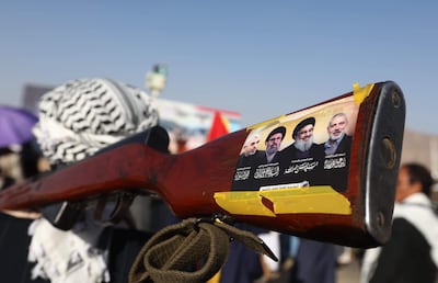 Un simpatizante de los hutíes lleva un arma con un cartel que representa a los difuntos líderes de Hamás y Hezbolá (de derecha a izquierda) Ismail Haniyeh, Hassan Nasrallah, Hashem Safieddine y Yahya Sinwar, durante una protesta contra Estados Unidos y Israel en Saná, Yemen, el 20 de diciembre de 2024.