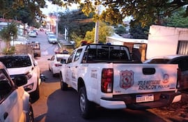 Calle urbana de Asunción con patrulleras de la Policía Nacional estacionadas, sin personas visibles en la imagen.