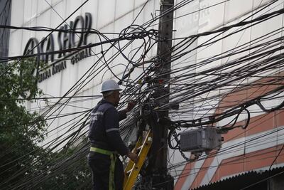 Un trabajador retira los cables de una columna de la zona céntrica de Ciudad del Este.