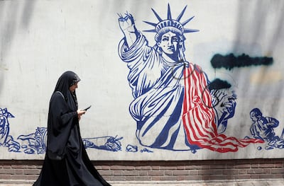 Una mujer pasa junto a un mural antiestadounidense cerca de la antigua embajada de EE. UU. en Teherán, Irán. Irán y EE. UU. intercambiaron disparos después de que el presidente estadounidense Trump declarara que el alto el fuego había terminado.
