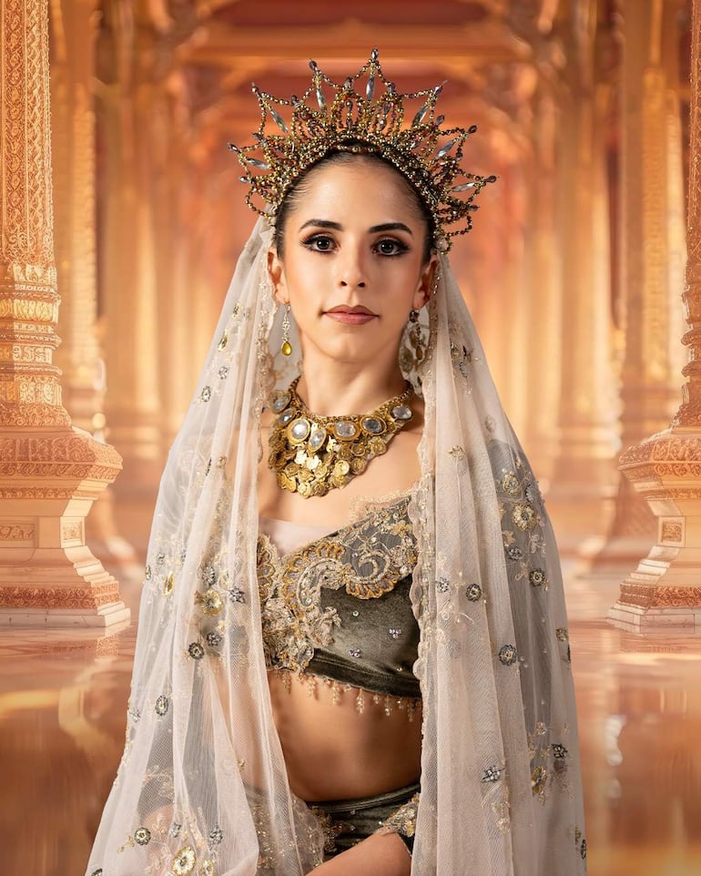 Mujer con velo blanco y accesorios dorados en primer plano, posando en un entorno elegante con columnas decorativas.