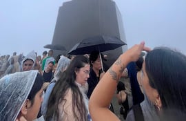 Fuertes lluvias en Río de Janeiro no impiden el disfrute a turistas. Imagen de personas con paraguayas y pilotos en el Cristo Redentor.