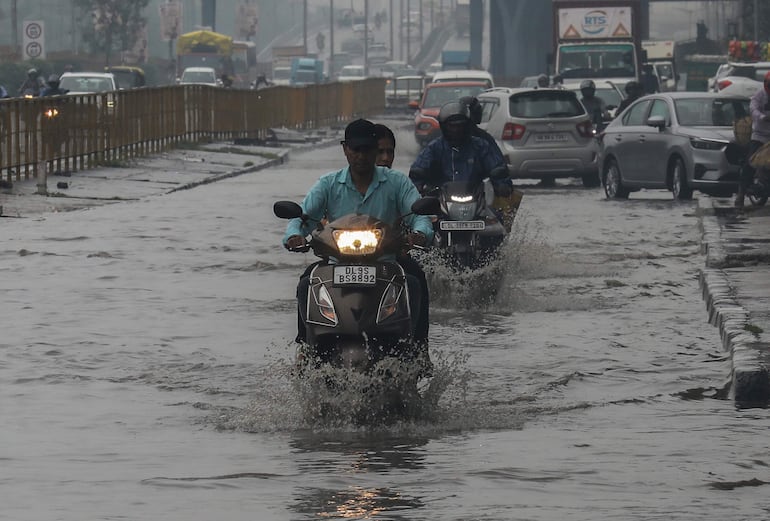 Motociclistas cruzan una vía inundada en la ciudad india de Faridabad.