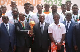 Abidjan (Cote D''ivoire), 13/02/2024.- President of the Ivorian soccer Federation Yacine Idriss Diallo (C-L) and President of Ivory Coast Alassane Ouattara (C-R) hold the Africa Cup of Nations trophy as they pose for a photo with the Ivory Coast soccer team during a reception at the Presidential Palace in Abidjan, Ivory Coast, 13 February 2024. Ivory Coast on 11 February won the CAF 2023 Africa Cup of Nations final against Nigeria. (Costa de Marfil) EFE/EPA/LEGNAN KOULA
