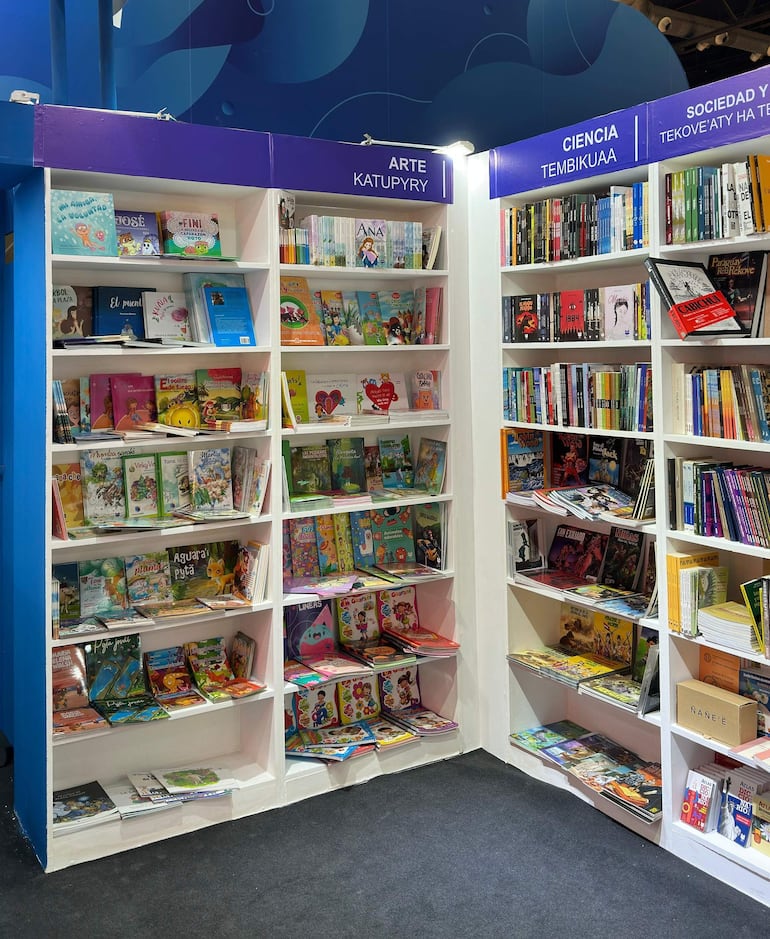 Estanterías con libros coloridos sobre arte y ciencia, en un ambiente acogedor durante la feria literaria.