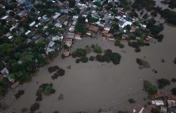 Vista aérea de barrios inundados en San Rafael, con casas visibles entre cuerpos de agua y vegetación.