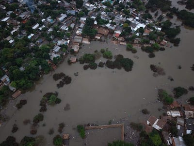 Vista aérea de barrios inundados en San Rafael, con casas visibles entre cuerpos de agua y vegetación.