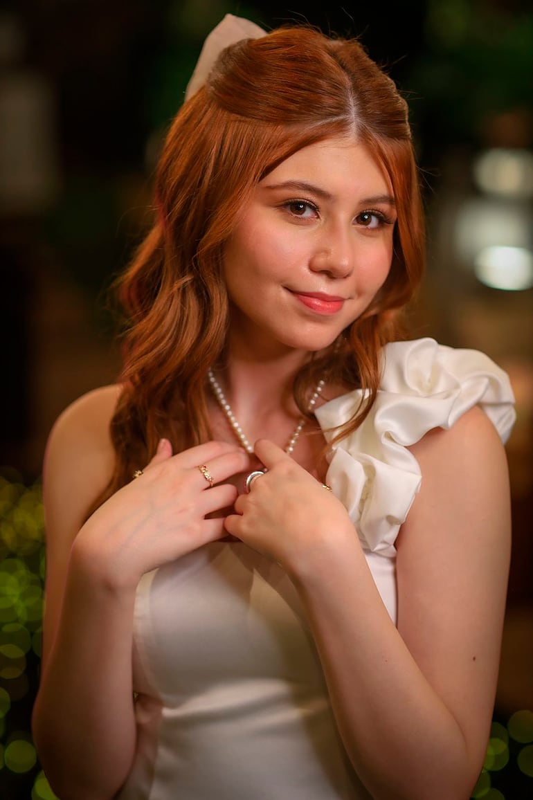 Collar de perlas y un delicado lazo complementaron el look.