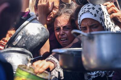 Varias personas intentan conseguir alimentos en un punto de distribución de ayuda humanitaria en Jan Yunis, en el sur de la Franja de Gaza, el pasado 27 de agosto.