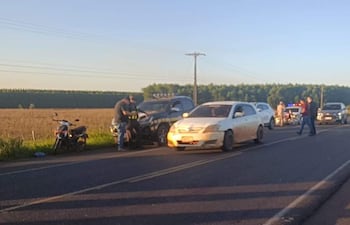 Efectivos policiales en ropa de trabajo cerca de vehículos detenidos en carretera, una moto visible al fondo.