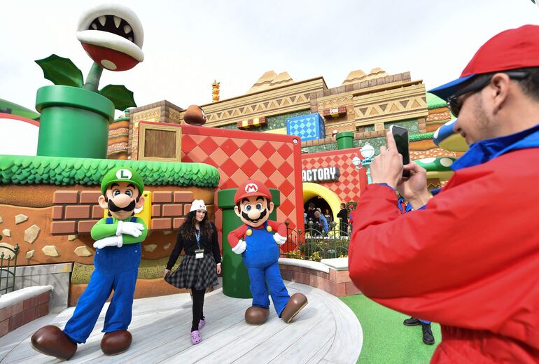 Foto de archivo tomada el 13 de enero de 2023; muestra a un empleado (D) tomando fotografías de los visitantes con Mario y Luigi durante una vista previa de Super Nintendo World en Universal Studios, en Los Ángeles, California.