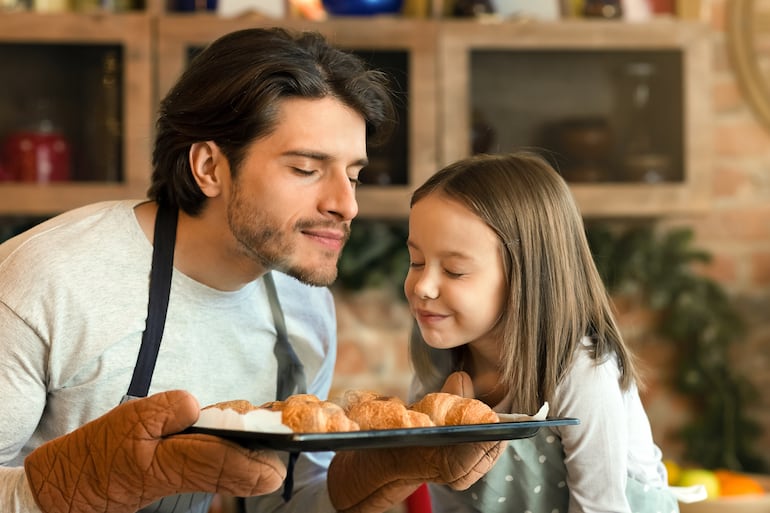 ¿A qué huele la felicidad?  Imagen de un padre y su hija oliendo masitas recién horneadas.