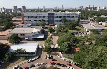 Vista aérea de un área urbana en Paraguay con un edificio destacado en el centro y vehículos estacionados.
