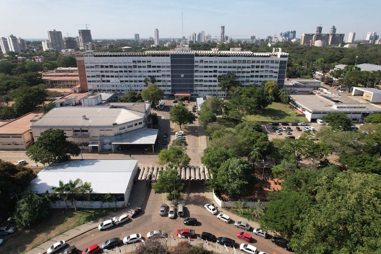 Vista aérea de un área urbana en Paraguay con un edificio destacado en el centro y vehículos estacionados.