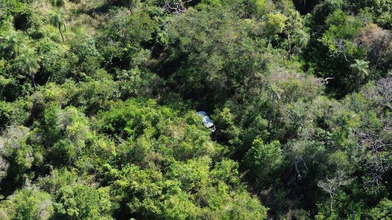 Vista aérea de un vehículo Toyota Fortuner oculto entre vegetación densa en un ambiente natural sin presencia de personas.