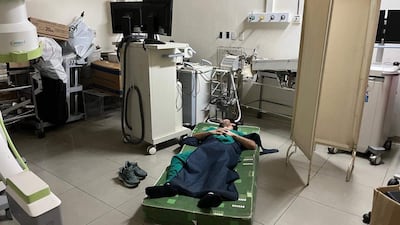 Un médico duerme en el suelo, tirado en un colchón rodeado de equipos médicos en el área de descanso del Hospital de Trauma.