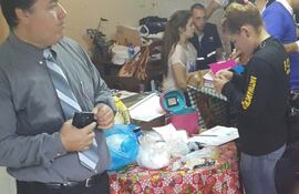 una-agente-de-la-policia-revisa-el-analisis-que-dio-positivo-a-cocaina-en-la-mesa-los-paquetes-de-la-droga--191620000000-1418482.jpg