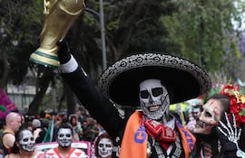 Personas caracterizadas como catrinas participan en el desfile de 'Catrinas Mundialistas' en Ciudad de México, México.