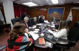 Isaías Ricardo Fretes, José Jara Rojas y otros en reunión, todos con actitud tranquila, revisando documentos en un ambiente serio.