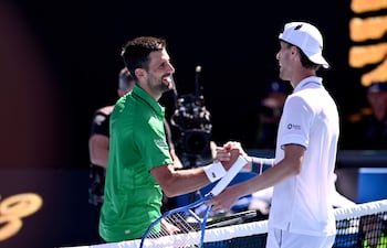 El serbio Novak Djokovic (i) saluda a su rival, el italiano Francesco Maestrelli tras concretar su triunfo número 101 en el Abierto de Australia y avanzar a tercera ronda.