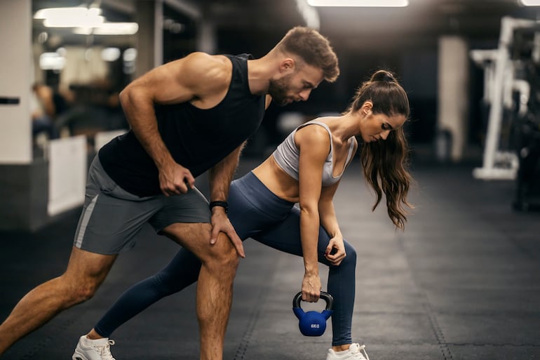 Una mujer y un hombre entrenan en el gimnasio.