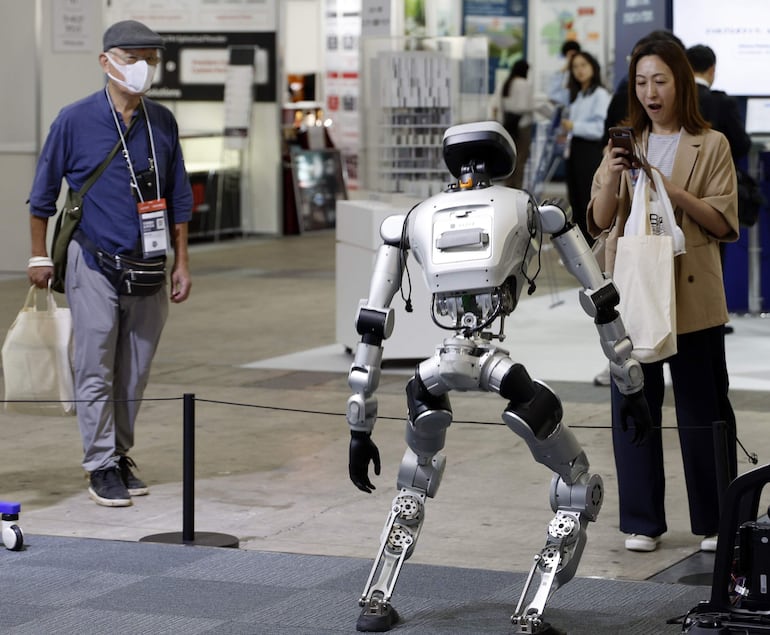 Un visitante reacciona cuando el robot Oli se pone de pie en el estand de LimX Dynamics, una empresa china de inteligencia artificial y robótica, durante la CEATEC 2026 (Exposición Combinada de Tecnologías Avanzadas), en Chiba, cerca de Tokio, Japón, el 13 de octubre de 2026.