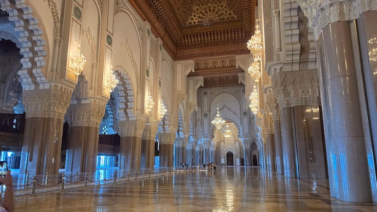 Interior majestuoso con arcos decorativos y columnas pulidas, iluminado por luz natural, sin personas protagonistas visibles.