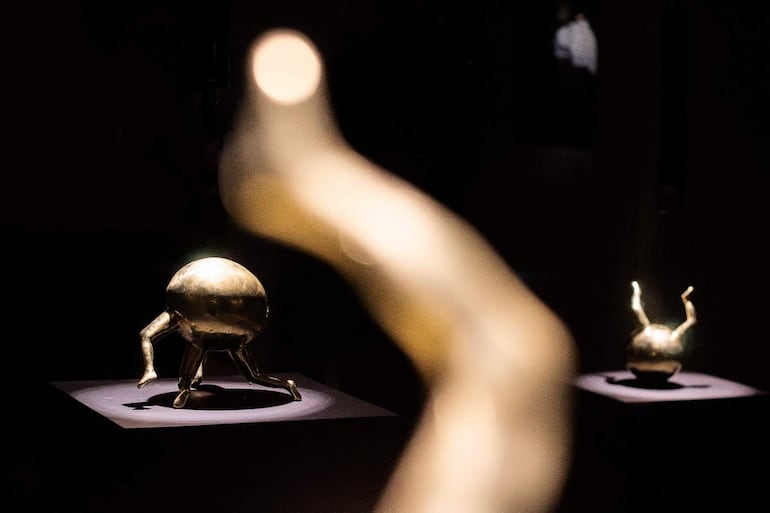 Tres esculturas de Laura Mandelik en un ambiente iluminado, resaltando su textura metálica y forma escultórica.